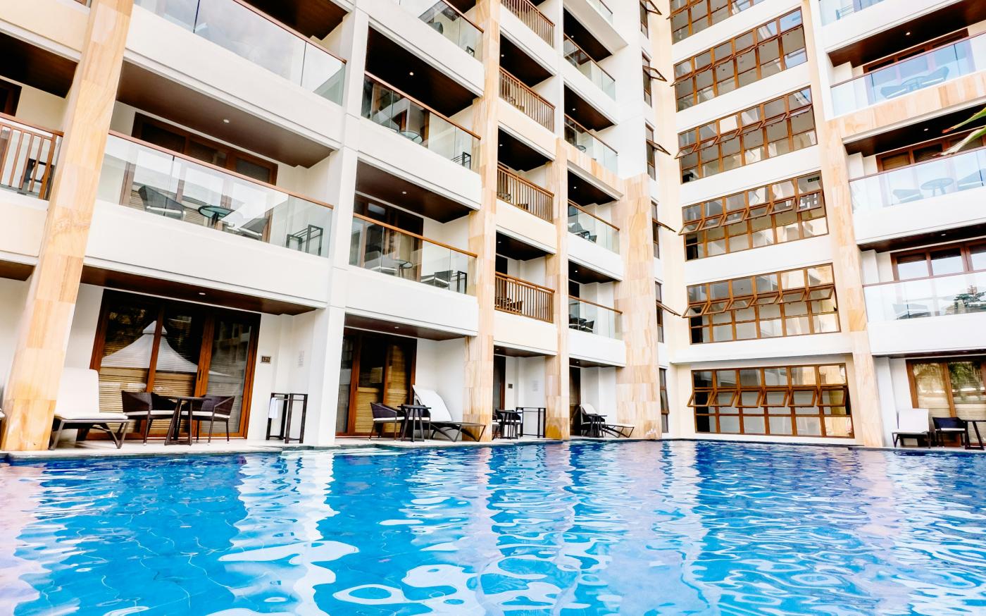 a large swimming pool next to a tall building by SJ 📸 courtesy of Unsplash.