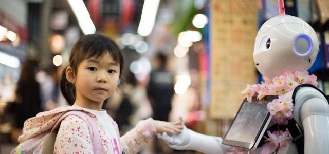 photo of girl laying left hand on white digital robot by Andy Kelly courtesy of Unsplash.