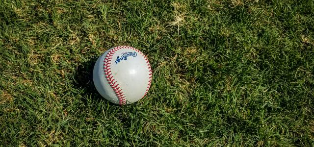 white and red baseball on green grass by Mick Haupt courtesy of Unsplash.