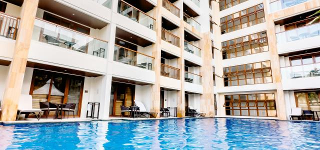 a large swimming pool next to a tall building by SJ 📸 courtesy of Unsplash.